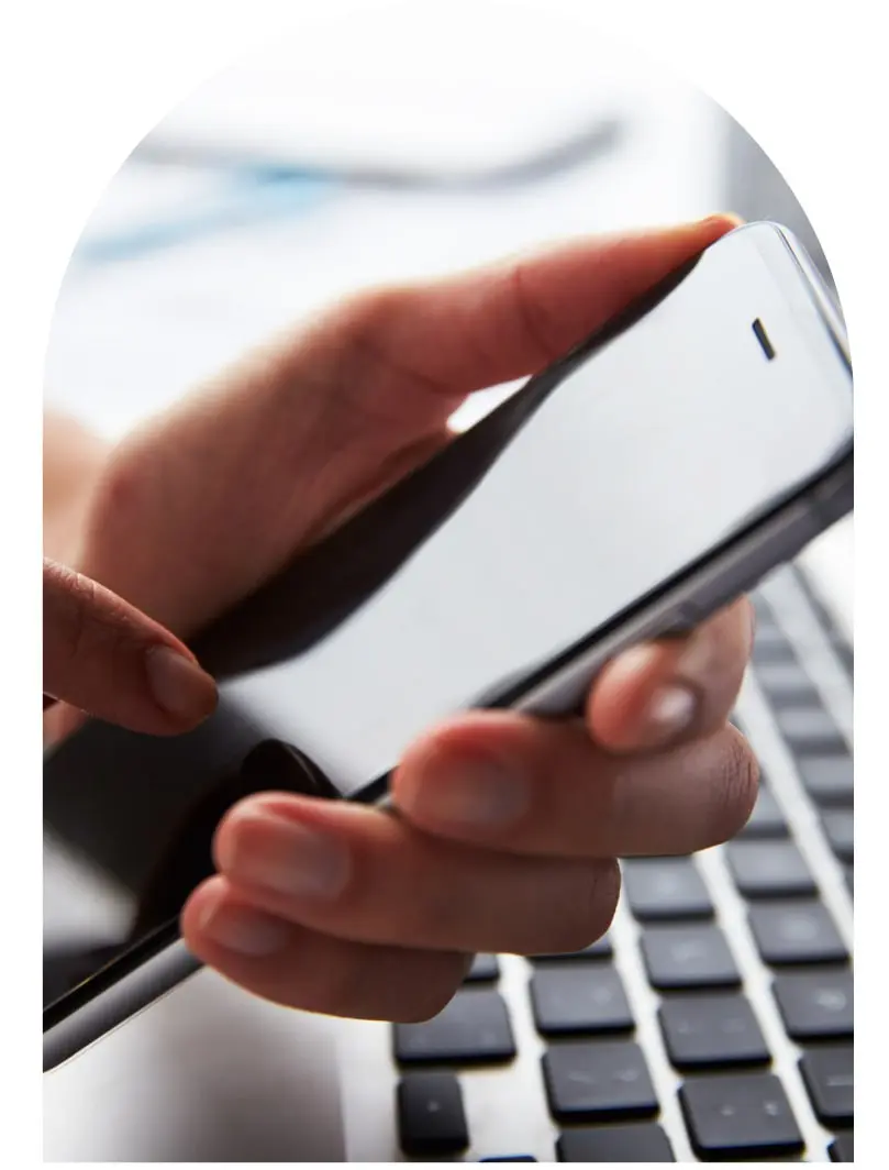 Person using smartphone and laptop for communication